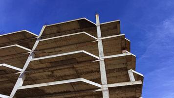 byggnad strukturera nå mot de klar blå himmel med betong balkar och oavslutat element visa upp modern arkitektur video