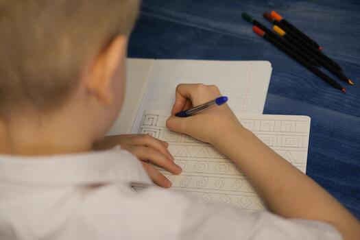 Child tracing patterns in notebook learning new skills photo