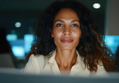IT support engineer focuses on tasks while illuminated by blue lights in a darkened office environment photo