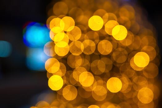 Soft bokeh of golden and colorful lights against a dark setting, creating a festive or romantic atmosphere with a blurred, warm vibe. photo