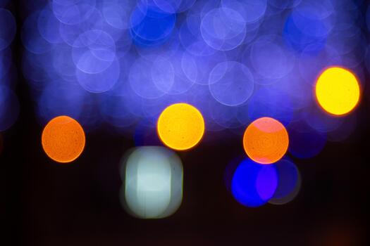 Out of focus golden and colorful light circles on a dark base, creating a magical, festive scene with a soft and enchanting effect. photo