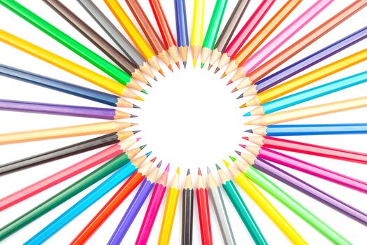 Multicolored pencils arranged in a circular pattern against a white backdrop, forming a central frame. Ideal for artistic projects, school supplies, or creative design concepts. photo