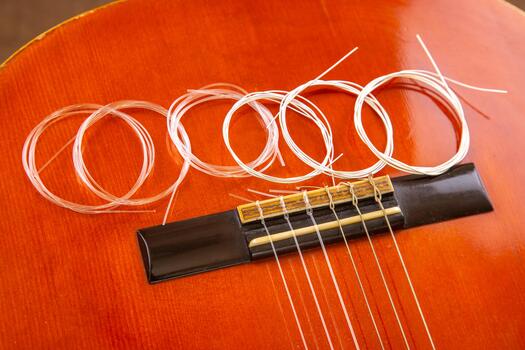 el rojo guitarra puente con recién equipado instrumentos de cuerda y un arrollado paquete de extra instrumentos de cuerda, capturado en un de cerca, enfatizando musical instrumento mantenimiento. foto