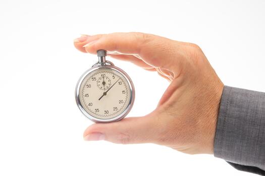 a hand with a mechanical analog stopwatch on a white background. Time part precision. Measurement of the speed interval photo