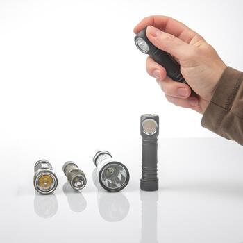 Exploring different types of flashlights with a hand holding one in a bright setting photo