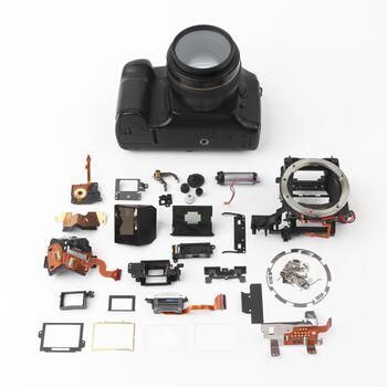 Camera disassembled with various internal components arranged for display and analysis photo