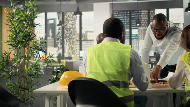 sitio desarrolladores y arquitectos en negocio reunión revisando planos y estructural diseños equipo discute reurbanización y ciudad planificación para residencial proyecto crecimiento. foto