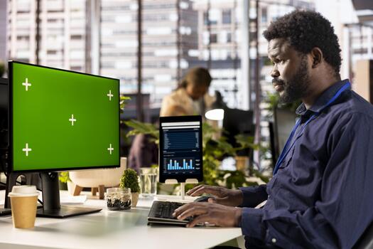 African american office worker verifying data analytics with copy space, using monthly infographics to create a financial report. Young man collecting performance metrics on computer. photo