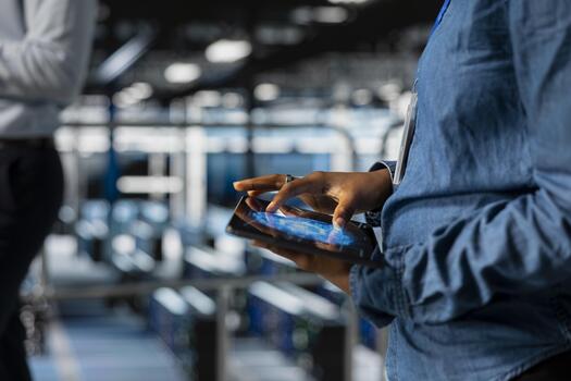 Close up of black woman engineer overseeing work done on tablet, using neural network LLM visualization and artificial intelligence. Server farm worker overseeing machine learning processes. photo
