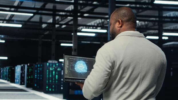 técnico utilizando ordenador portátil en datos centro, gerente servidor virtualización, corriendo guiones. eso experto utilizando programación idioma en cuaderno en servidor centro, sintonia FINA red protocolos, cámara si foto