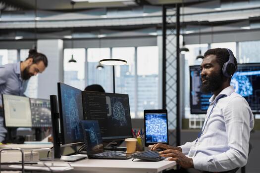 Tech startup admin integrating AI machine learning systems in office, listening music. Engineer wearing headphones uses neural networks artificial intelligence, technology overload concept photo