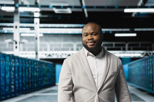 Cheerful technician doing yearly checkup to prolong data center hardware life span and avoid downtime. Upbeat man in server room monitoring server infrastructure components photo