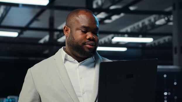 datos centrar sistema administrador codificación en computadora portátil, haciendo software actualizaciones servidor habitación eso especialista mirando a dispositivo pantalla, optimizando infraestructura montajes en rack configuración plataformas, cámara si foto