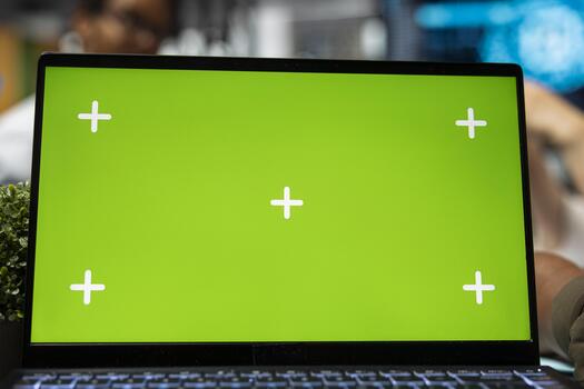 Chroma key laptop next to IT workers brainstorming app development in AI startup office. Engineers optimizing performance with artificial intelligence tech on isolated screen notebook, closeup photo