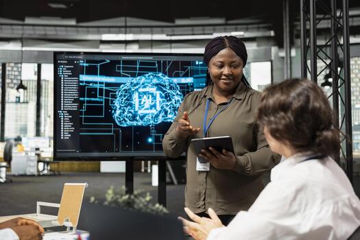 IT professionals doing meeting in company conference room, implementing AI solutions to increase productivity. Multiethnic technicians discussing machine learning models roadmap in startup office photo