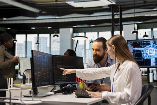 Friendly team leader mentor explaining young software engineer how to use AI tech. Joyous supervisor guiding office newcomer through AI tool integration, mentoring her on using neural networks APIs photo