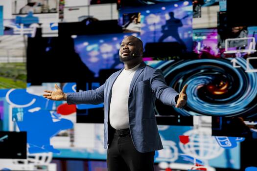 African american public speaker discussing with audience about social media platforms, points at dynamic screens for entertainment and web communication. Networking advice for engagement. photo