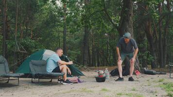 två män laga mat och prata tillsammans, två individer samarbeta på matlagning medan har vänlig chatt, par av män arbete samtidigt på framställning måltid och njuter konversation genom hela video