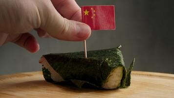 stänga upp se av triangel- ris insvept i tång med kinesisk flagga, ram föreslår kinesisk version av onigiri använder sig av inrikes vuxen ris och inte jag heller stil tång. video