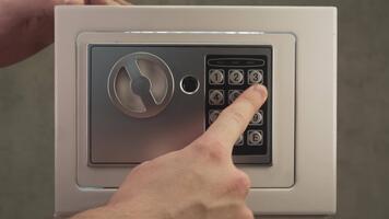 stänga upp skott visar person placering minne kort med kompromiss foton eller konfidentiell data inuti säker, sedan fast stängning dörr och låsning den med koda till ha kvar information dold. video