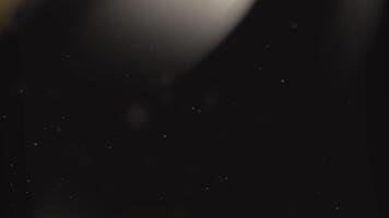 elegant abstrakt bakgrund med gyllene ljus strålar, mjuk glöd, och flytande partiklar på en mörk bakgrund. video