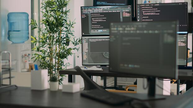 Empty desk with multiple monitors displaying server code and programming language, compiling in software developing agency office. System cloud computing online database algorithms. photo