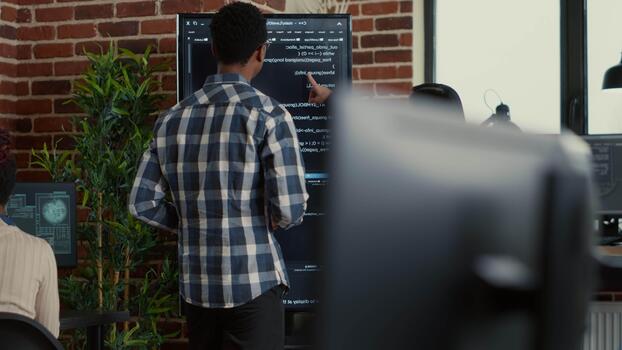 software desarrollo equipo estudios pared pantalla código durante un depuración sesión con un digital tableta, enlace error comprobación, sistema diagnósticos y colaborativo, durante un enfocado algoritmo tarea. video