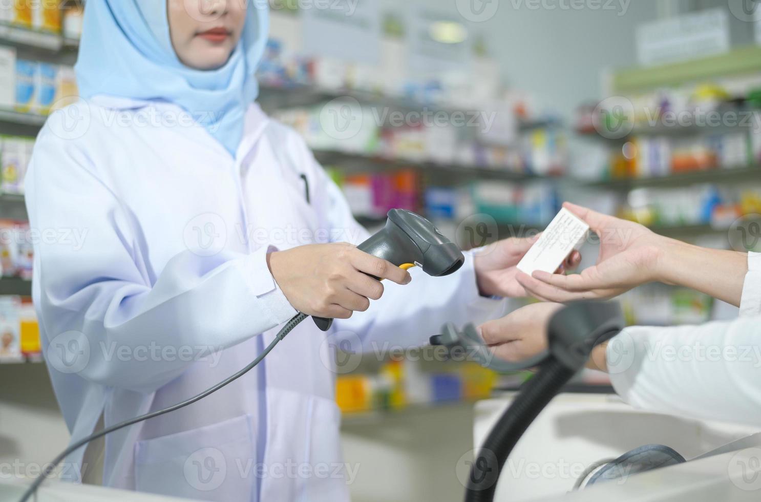 farmacista musulmano femminile che scansiona il codice a barre in una moderna farmacia. foto