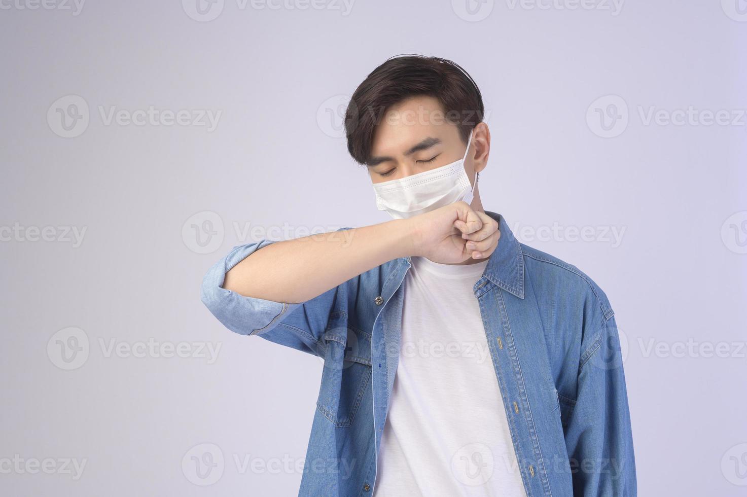 giovane uomo asiatico che indossa una maschera protettiva su sfondo bianco studio, viaggi di sicurezza, nuova normalità, distanza sociale, covid19 e concetto di pandemia. foto