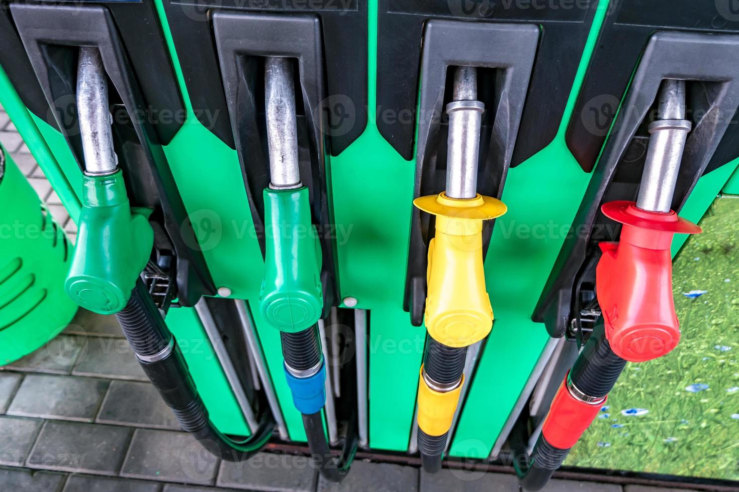 distributore di benzina e benzina. pistole per il rifornimento in una stazione di servizio. dettaglio di una pompa di benzina di diversi colori nella stazione di servizio. primo piano sull'ugello del carburante nel distributore di olio con benzina e diesel foto