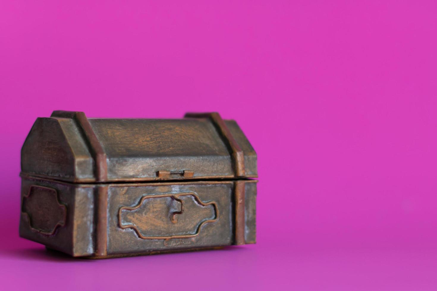 una vecchia scatola di metallo su sfondo rosa. foto