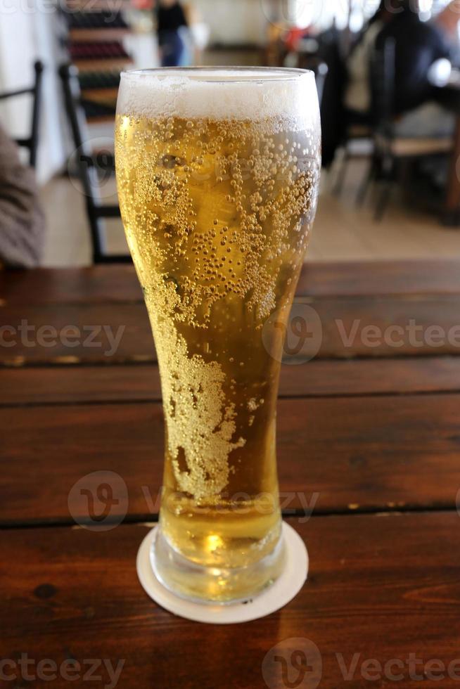 sul tavolo in un bicchiere di birra fresca e fredda. foto