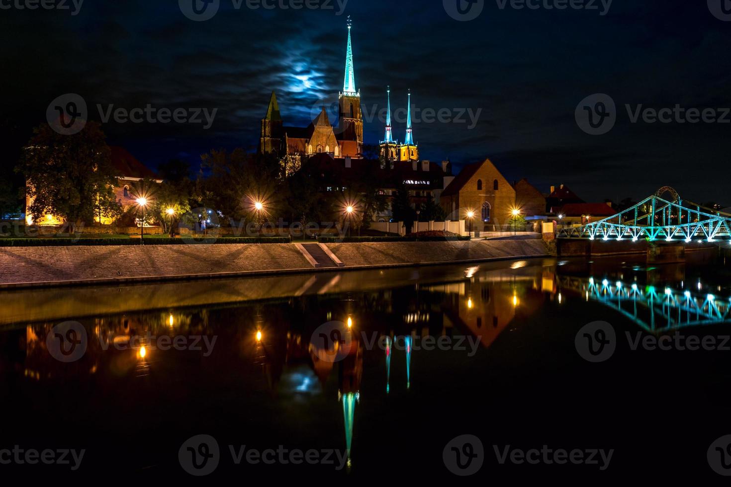 riflessione panoramica con vista lunare della città vecchia architettura e argine del fiume oder e quartiere storico ostrow tumski con le guglie illuminate della cattedrale gotica di wroclaw, polonia foto