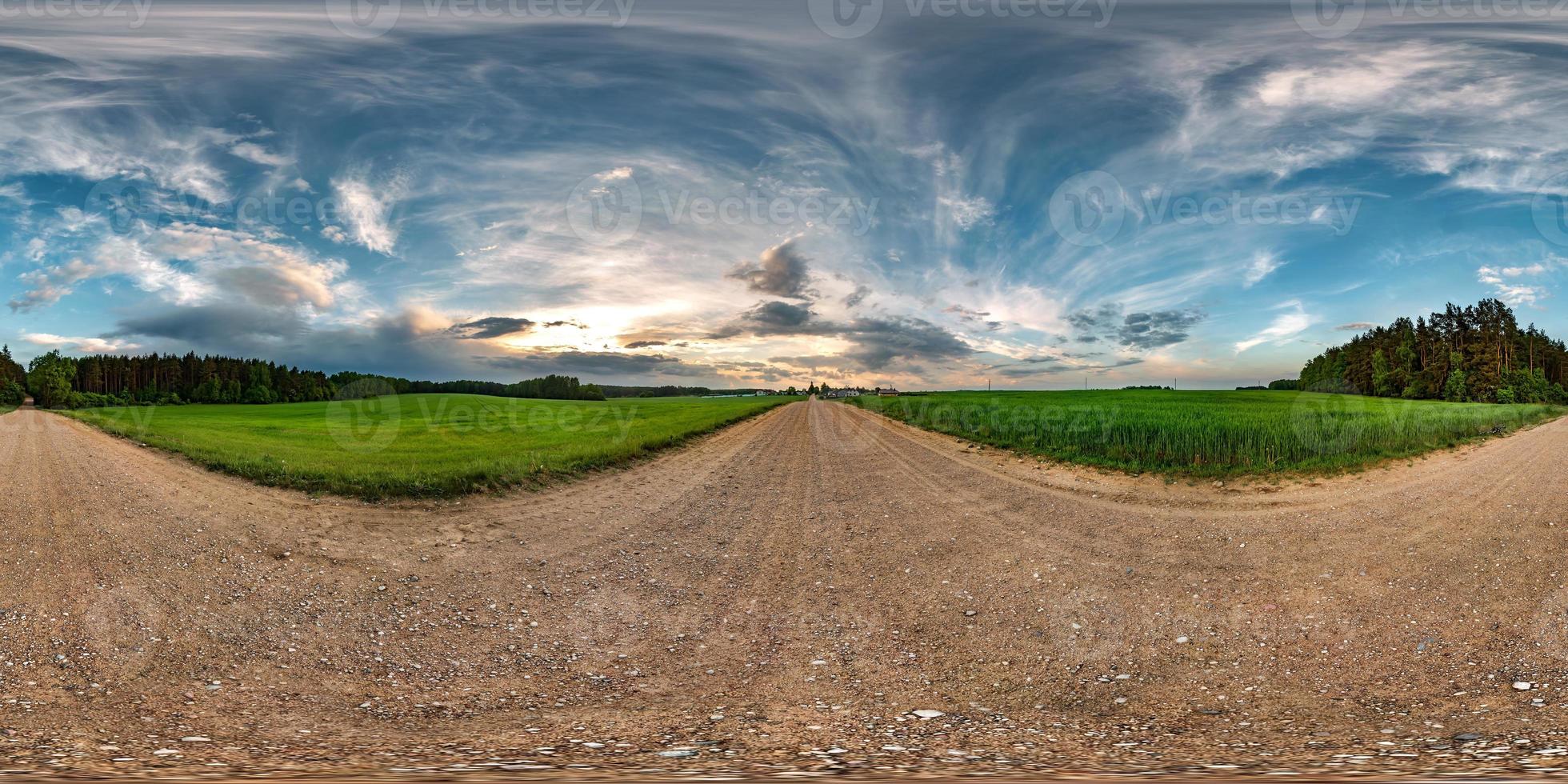 panorama hdri sferico completo senza soluzione di continuità vista a 360 gradi su strada sterrata tra i campi in estate tramonto serale con fantastiche nuvole in proiezione equirettangolare, contenuto di realtà virtuale vr ar pronto foto