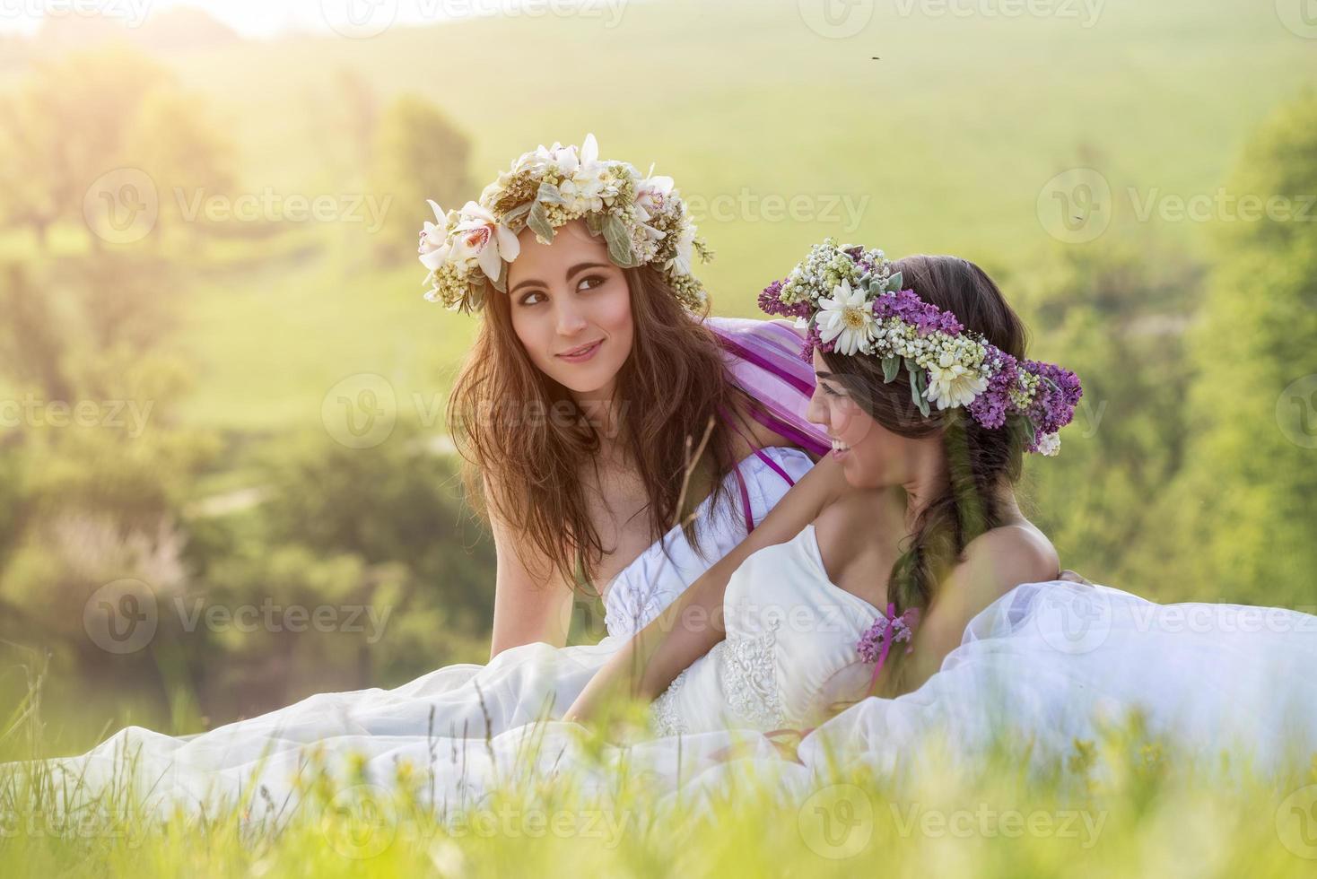 2 bella sposa all'aperto, seduto sull'erba foto