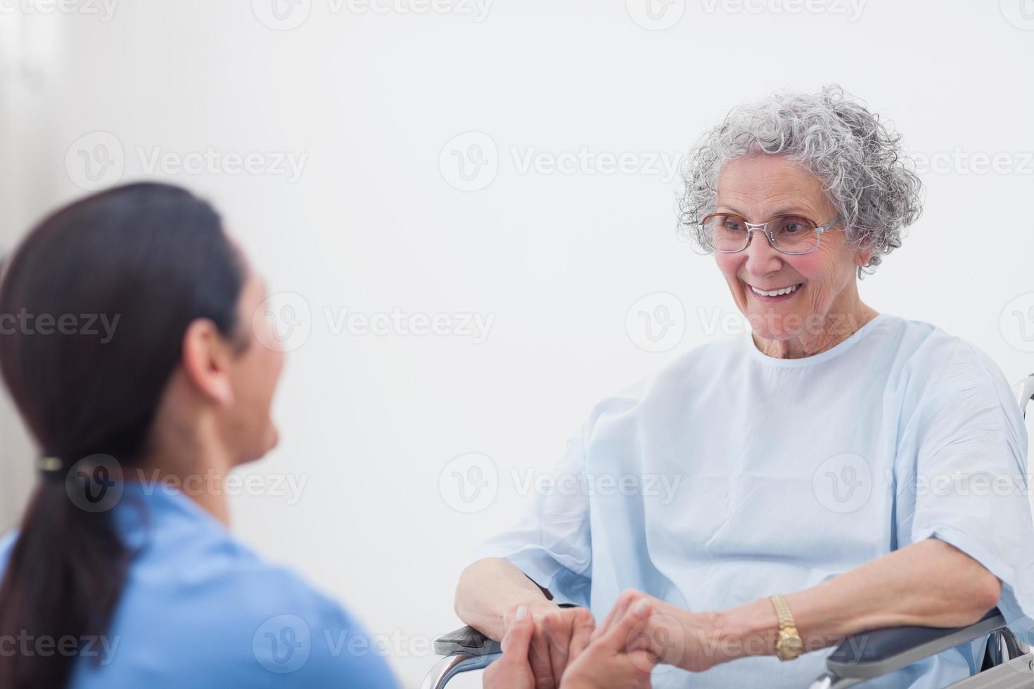 infermiere che tengono le mani di un paziente foto
