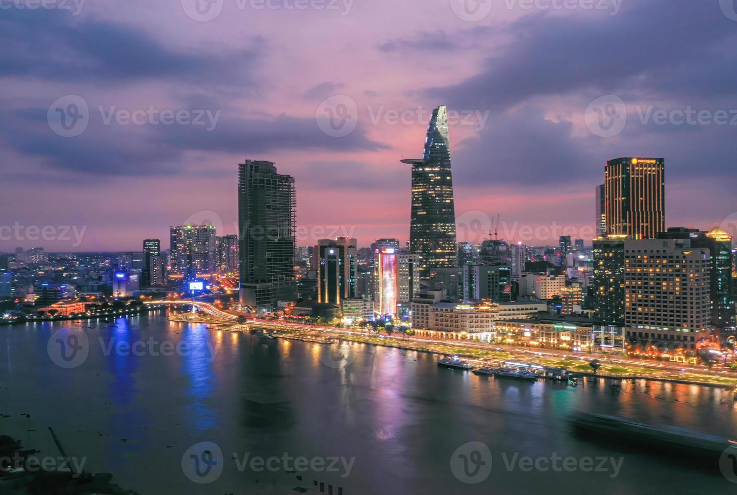 vista dell'edificio della torre finanziaria bitexco, degli edifici, delle strade, del ponte di thu thiem e del fiume Saigon nella città di ho chi minh al tramonto. immagine panoramica di alta qualità. foto