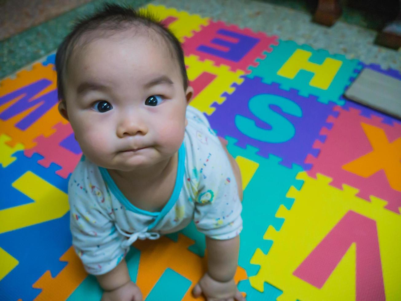 carino bambino asiatico sulla schiuma del bambino per il parco giochi per bambini foto