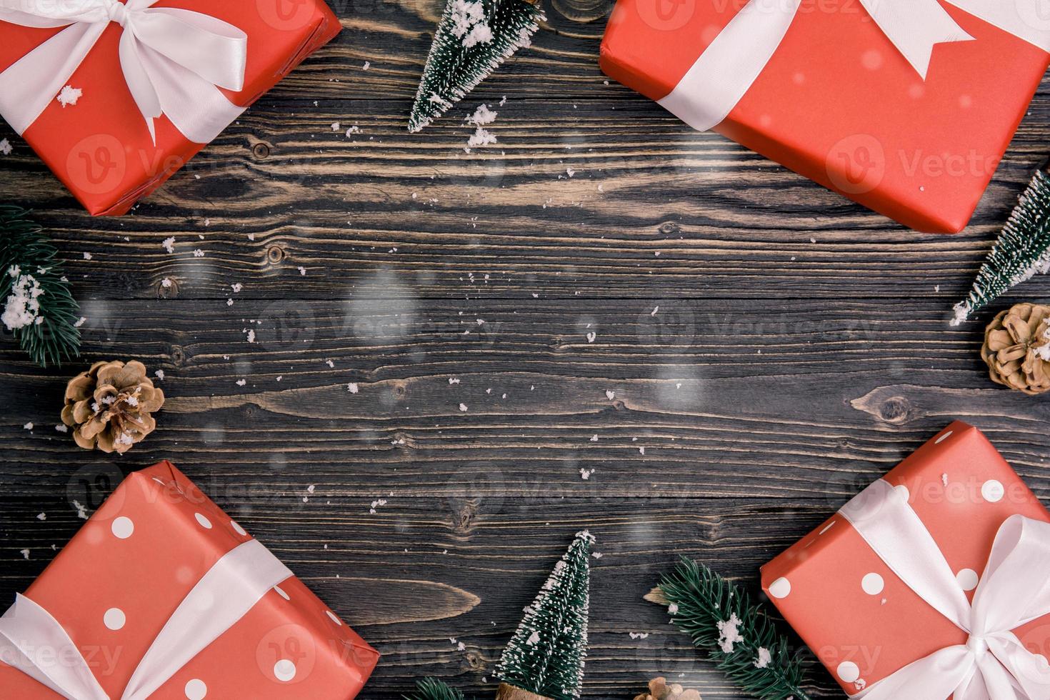 composizione per vacanze di natale con confezione regalo rossa e decorazione tag su sfondo di legno, capodanno e natale o anniversario con regali su tavola di legno in stagione, vista dall'alto o distesa. foto