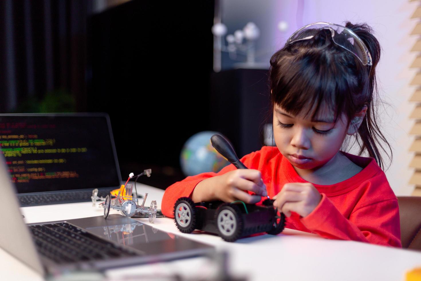 gli studenti asiatici imparano a casa a codificare auto robot e cavi di schede elettroniche in stelo, vapore, matematica ingegneria scienza tecnologia codice informatico in robotica per bambini concetto. foto