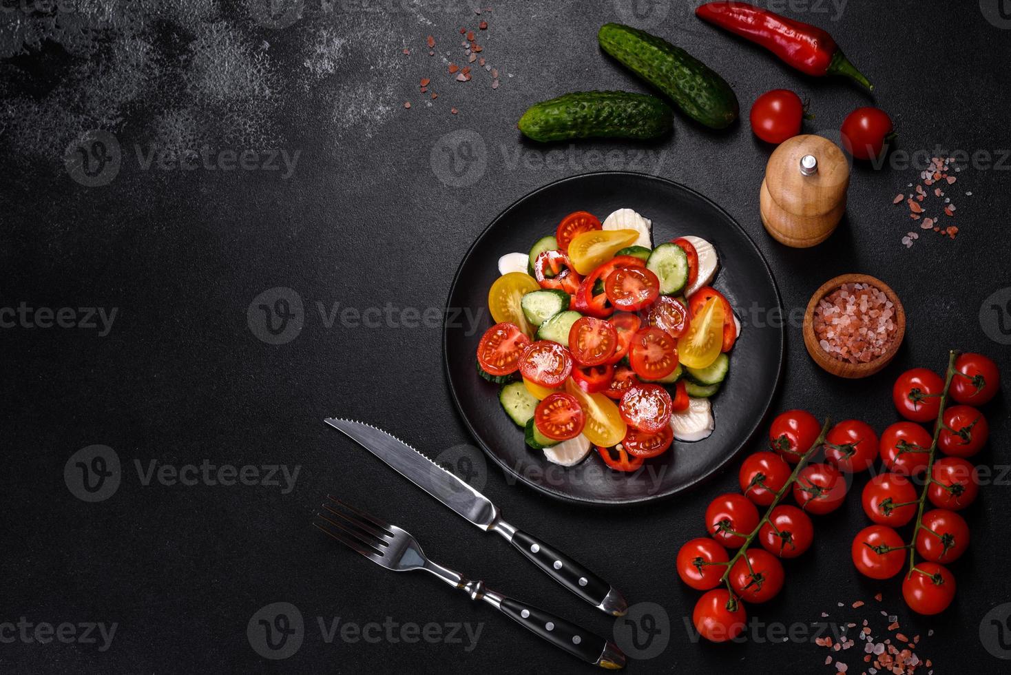 fresca e deliziosa insalata con pomodorini, cetrioli, peperoni dolci, formaggio e olio d'oliva foto