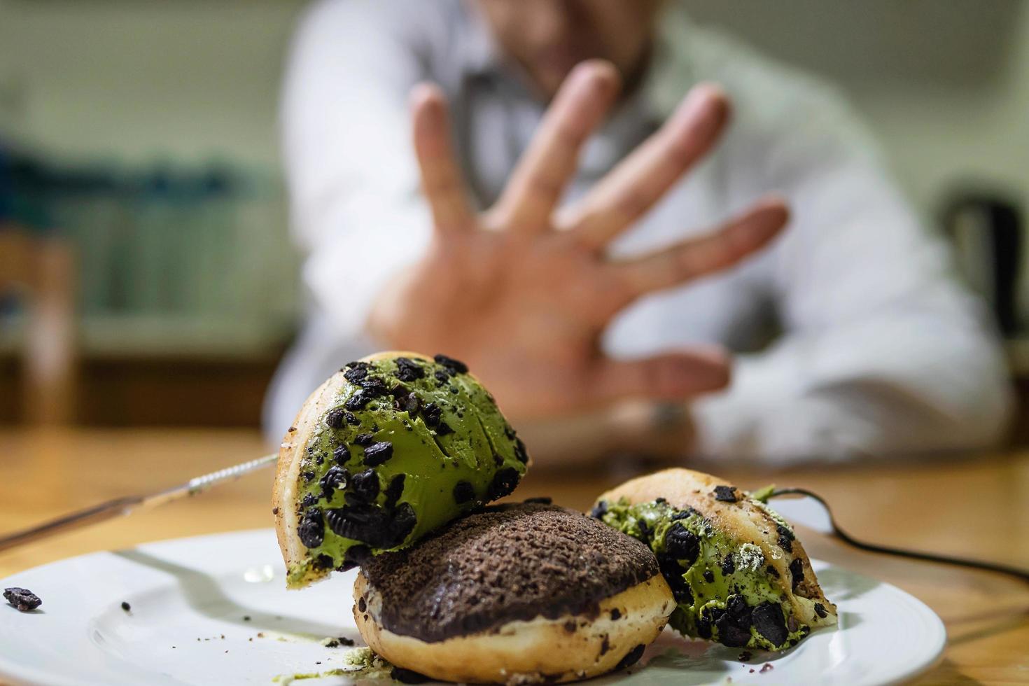 ragazzo non è d'accordo a mangiare la ciambella foto