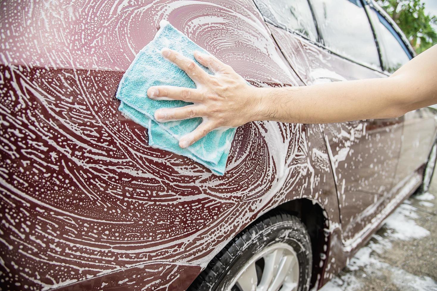 l'uomo lava l'auto usando lo shampoo - concetto di cura dell'auto per la vita quotidiana foto