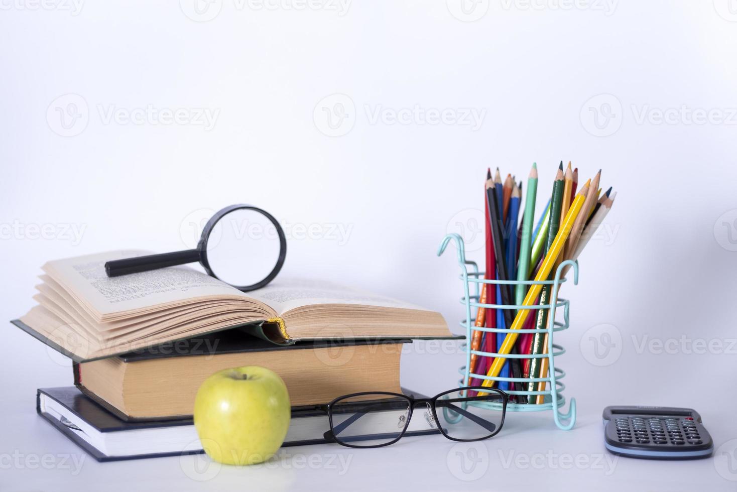 una pila di libri, guide di studio, libri di testo, occhiali e matite in un portacopia di testo. foto