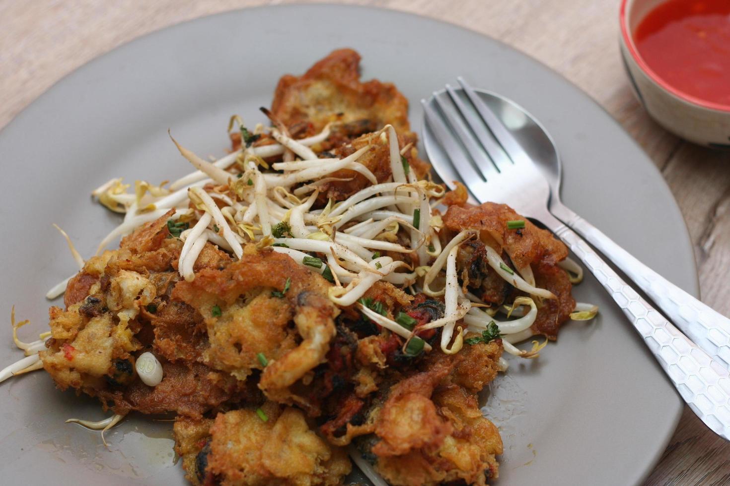 ostriche fritte in pastella di uova, cozze croccanti saltate in padella con germogli di soia, cozze croccanti e frittella di germogli di fagioli foto