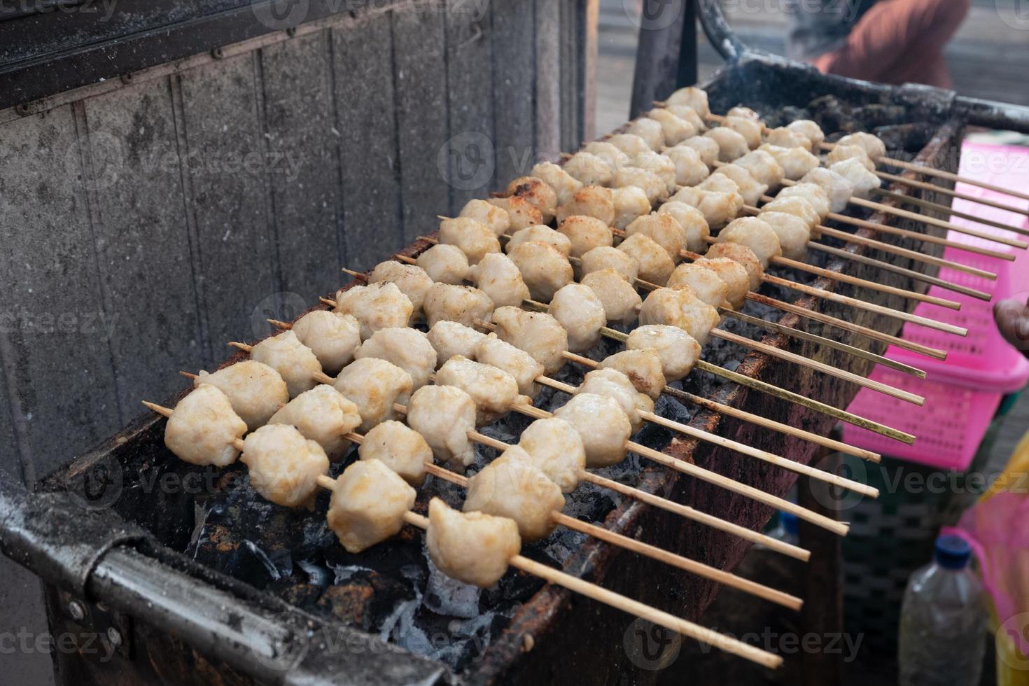 messa a fuoco selettiva su polpette alla griglia infilzate con bambù e vendute ai festival culinari foto