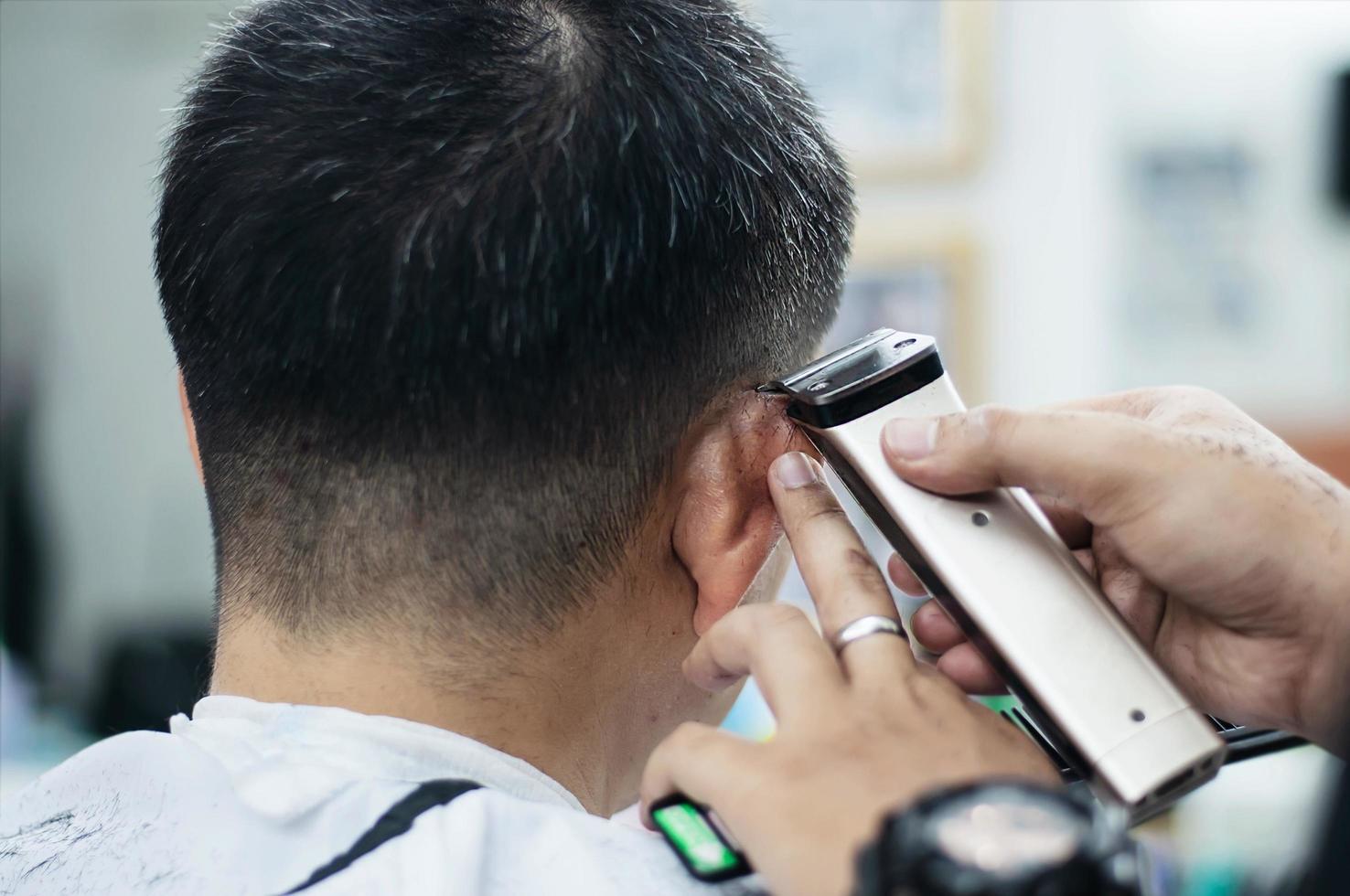 l'uomo si taglia i capelli nel negozio di barbiere - persone nel concetto di salone di bellezza parrucchiere foto