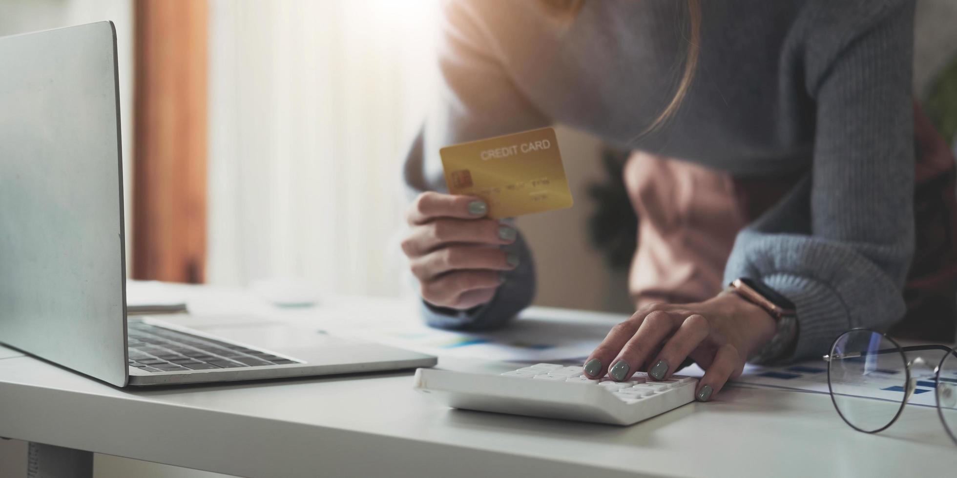 donna asiatica che controlla le bollette, le tasse, il saldo del conto bancario e calcola le spese della carta di credito a casa. foto