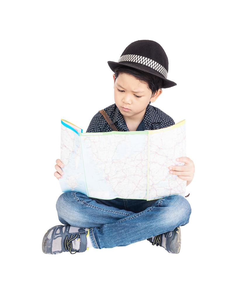 Il ragazzo asiatico di 7 anni è felicemente seduto e guardando una mappa foto