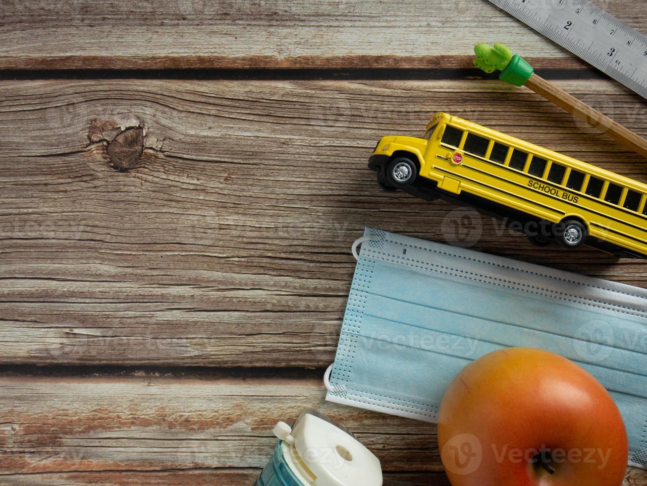 scuolabus e maschera sul tavolo di legno per l'istruzione o il concetto medico foto